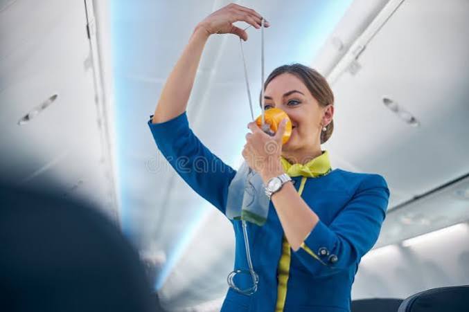 Flight attendant demonstrating oxygen mask — a metaphor for senior dog caregiver self-care