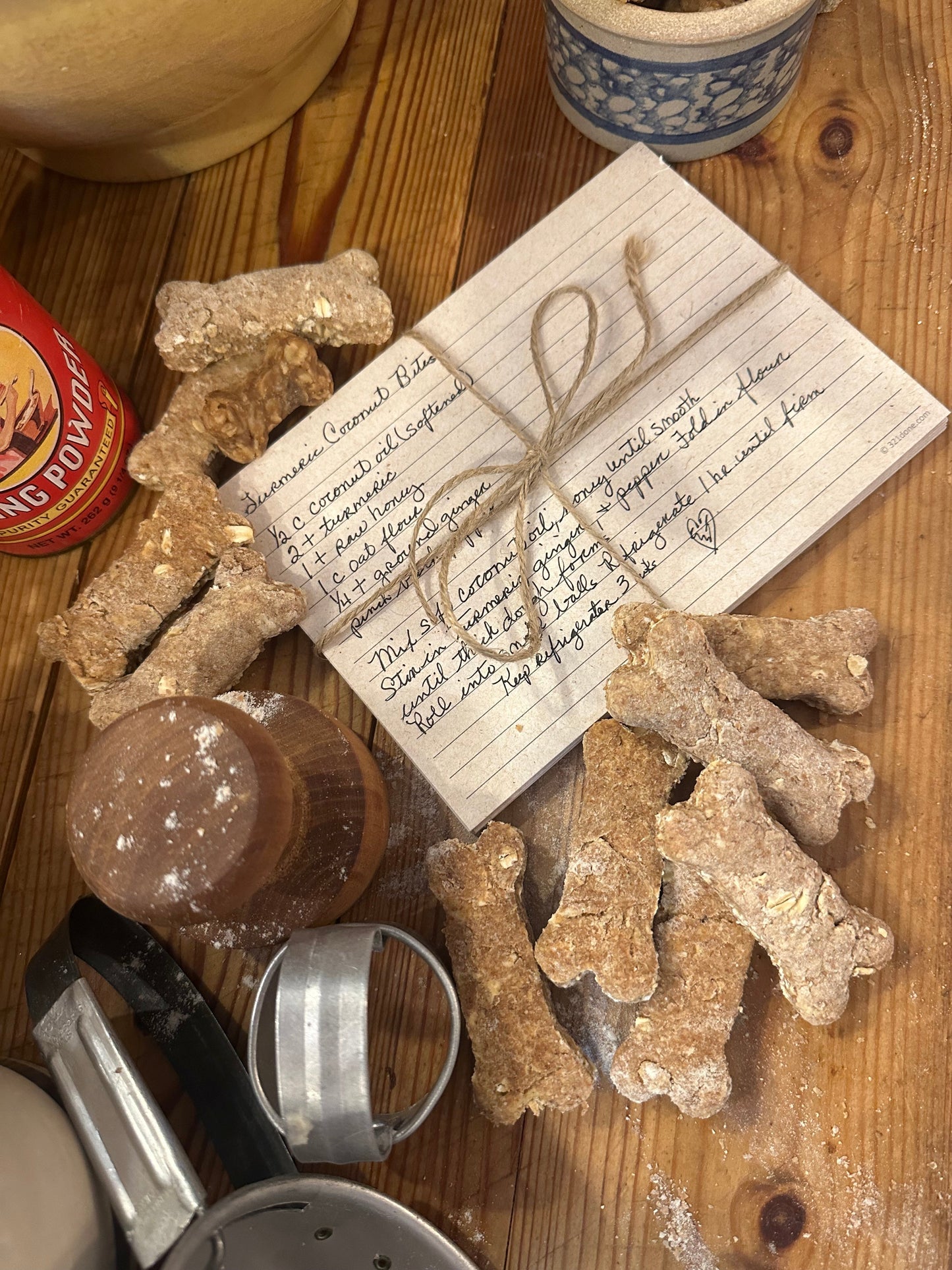 Overhead view of baked bone-shaped treats surrounding tied recipe card