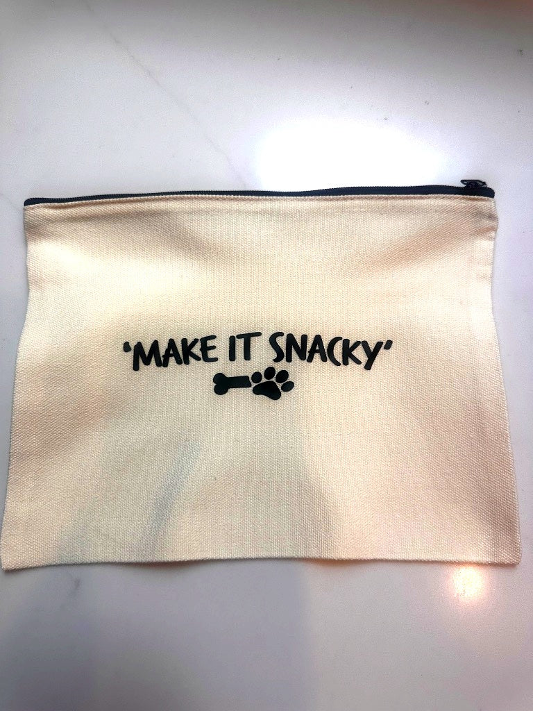 Beige pouch with 'MAKE IT SNACKY' text and bone design on a white background
